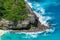 Vertiginous, swirling foamy water waves at the ocean photographed from above cliff.