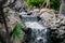 Very beautiful artificial waterfalls with living water and growing moss. Water flows from above, splashes and drops around