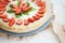 Very beautiful summer cheesecake decorated with strawberries - stands on a white wooden table, close-up