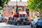 Very big red combine tractor with rubber tracks and massive exhaust as unique individual wedding car with ribbons parked road