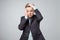 Very bored adult man holding hand on cheek, looking tired and sick, over gray background.