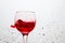 Very bright wine splashing in a glass on a gray abstract background