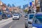 A very busy Sydney Road in Brunswick on a sunny day, with the Melbourne city skyline in the distance