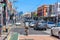 A very busy Sydney Road in Brunswick on a sunny day, with the Melbourne city skyline in the distance