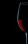 Very close up view on wineglass with red wine on black background