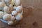 Very close view of dish of small white mushrooms on wood background, selective focus, copy space