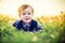 Very cute toddler smiling portrait in white dandelion meadow