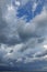 Very dark stormy clouds over commercial port cranes, vertical composition