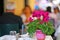 Very decorative fuchsia cyclamen vase on the table set for lunch in a restaurant in Corfu