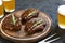 Very delicious steak BBQ and beer in glasses on a black stone background