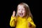 Very excited and screaming little girl in yellow, in dark room