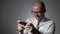 Very expressive and emotional Manager in white shirt and tie playing games on his smartphone.