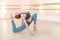 Very flexible caucasian woman doing stretching exercises in dance class with mirrors and barre.