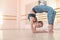 A very flexible woman wearing sportswear stands in a bridge pose in a dance class with mirrors and ballet machines