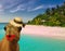 Very funny travel concept camel wearing make up and lady straw hat at a tropical beach