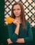 A very girl standing near a green carved door