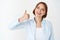 Very good. Portrait of businesswoman showing thumb up, like and approve, say yes and agree, standing in blouse on white