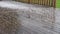 Very intensive summer hail storm on wet wooden terrace and green grass. Panning, zooming in and out video on frozen hailstones.