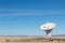 Very Large Array detail of radio antenna against a blue sky and distant mountains, listening to space