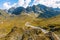 Very large and majestic alpine landscape in the Lord of the Rings style. In the foreground are some rocks, in the