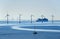 A very large passenger ship and a small sailboat pass offshore wind turbines near the Oresund Bridge between Denmark and Sweden