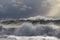 a very large wave on a choppy ocean with white foam