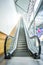 Very long escalator beside the glass to outdoor side