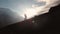 Very long shot Aerial view of epic shot of a man walking on the edge of the mountain as a silhouette in a beautiful