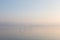 A very minimalistic view of a lake at dawn, with soft light, war