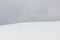 A very minimalistic view of two distant people over a mountain covered by snow