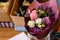 Very nice florist woman holding a beautiful colourful blossoming flower bouquet of peony, carnations, roses, eustoma