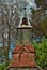 Very old mausoleum built into the side of a hill with steeple, tombstones, and wrought iron fence