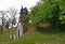 Very old mausoleum built into the side of a hill with steeple, tombstones, and wrought iron fence