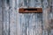 Very old postbox in wheathered wooden fence