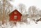 Very old red wooden house in a snowy forest