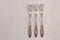 Very old set of three rusty vintage silver forks on a white cement texture background