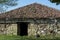 Very old stone building house with red roof and entrance in forest