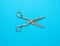 Very old vintage metal tailor scissors on a blue background