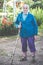 Very old woman standing, holding cane