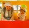 Very older grandmother talking with her little granddaughter on playground, both wearing bonnets, red blank board