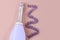 Very Peri champagne bottle on pink background with violet lace ribbon