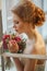 Very pretty sophisticated red-haired girl with a bouquet in his