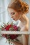Very pretty sophisticated red-haired girl with a bouquet in his