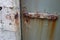 very rusty old door interlock . long brown rust corrosion . red grate scale of iron on grey metal . oxidation process science