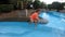 A very small child splashes his feet in the pool.