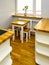 Very small kitchen room with natural wood floor window sill and furniture surfaces, white shelves