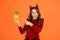 Very spooky. Happy girl point finger at pumpkins orange background. Small child with spooky Halloween look. Have