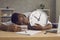 Very tired or lazy black man sleeping at his desk not knowing he's late for classes