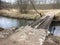 A very unsafe iron bridge over a stream