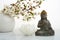 Vesak, Wesak, Buddha birthday. Buddha statue with blossoming cherry on white background. Spa ritual. Mental health and